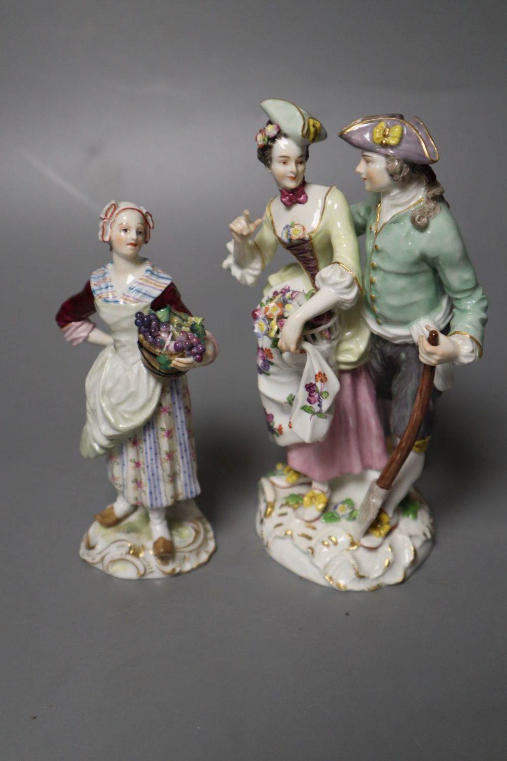 A Meissen group of a gardener and companion and a Meissen figure of a fruit seller, tallest 15cm (2)